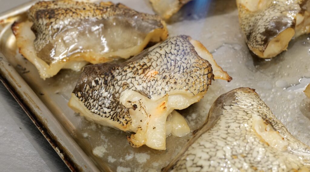 銀むつの皮目をバーナーで炙り、香ばしさと焼き目をつけている工程中のカット
