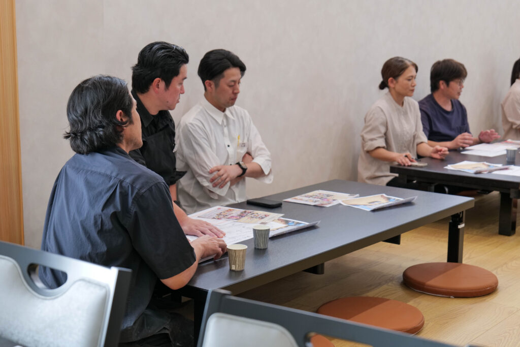 既存スタッフと新メンバーが打ち合わせをしている様子