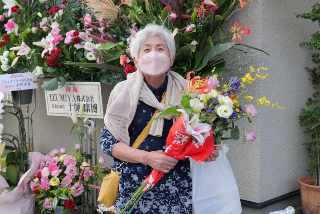 笑顔で花を手にするお客様
