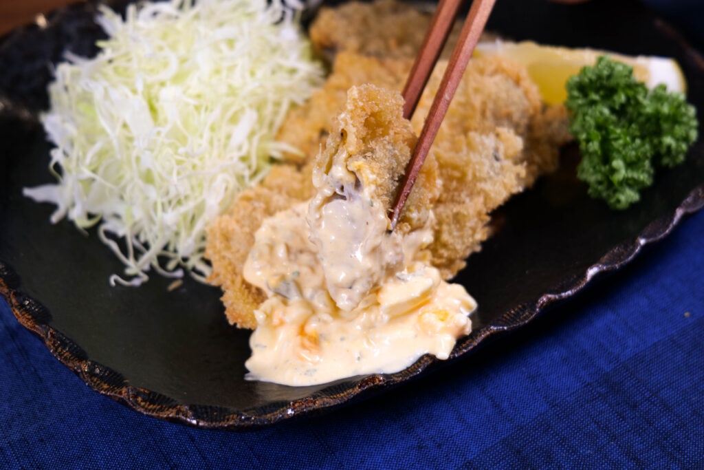 箸で持ち上げたカキフライのカット
