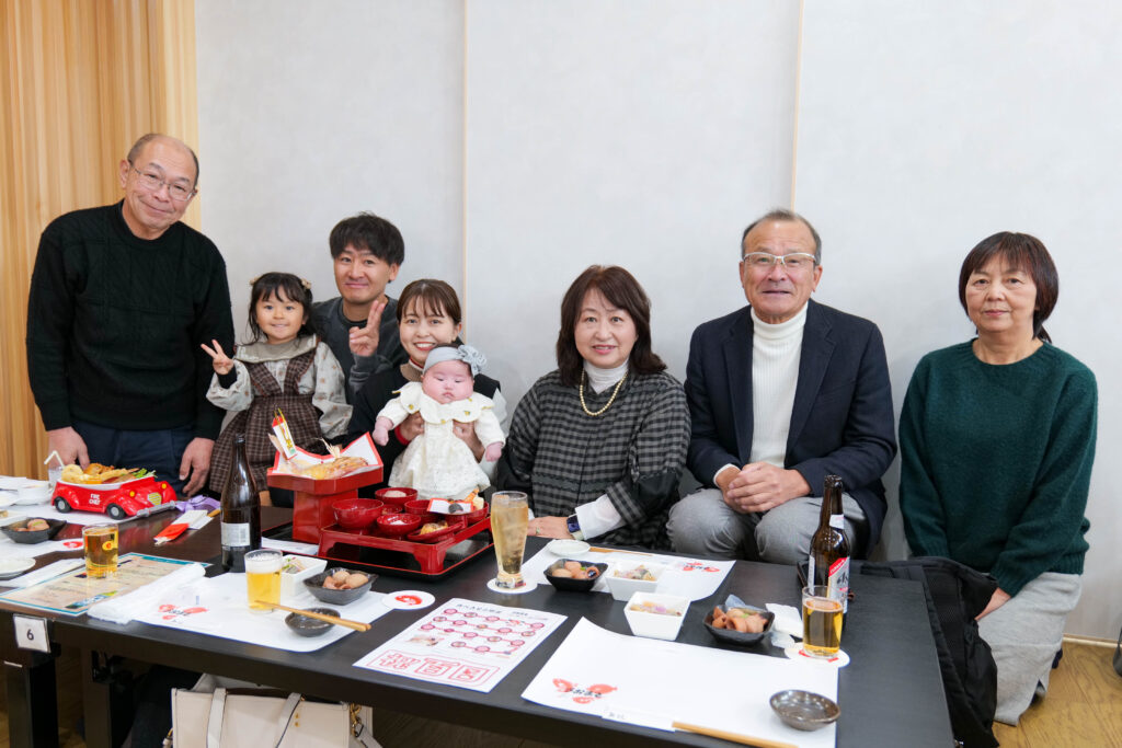 魚政の2階広間で行うお食い初めの家族写真と祝い膳