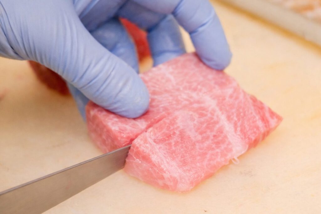 大トロを丁寧に切りつけている様子 さかなやうおまさ