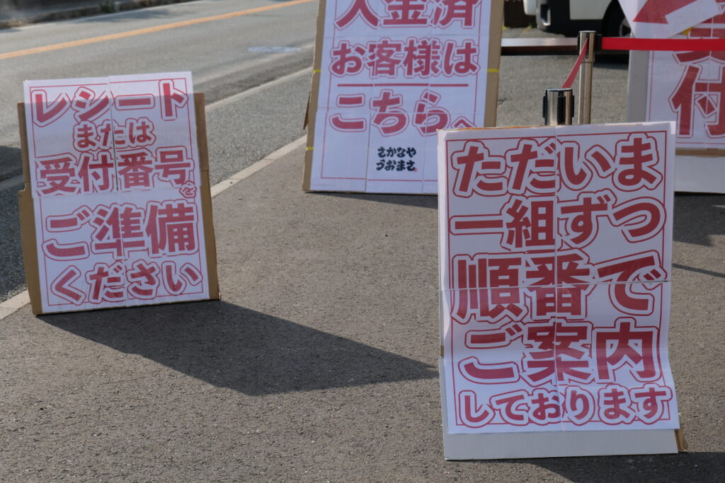 うおまさ特設会場でスタッフがお客様をご案内している様子。