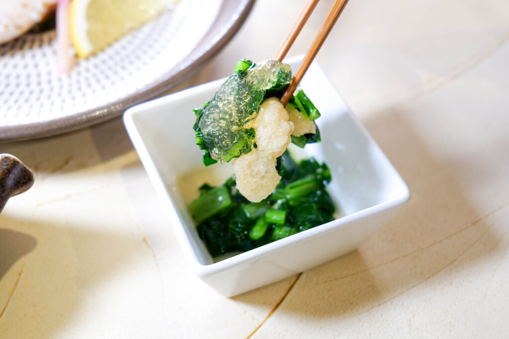 だしジュレが絡むおひたし。箸で持ち上げた一口（魚政（うおまさ）冬コース）