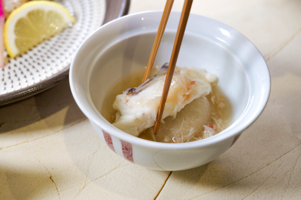 本ずわい蟹あんのかぶら蒸しを箸で持ち上げた一口。とろみが伝わるカット（魚政（うおまさ））