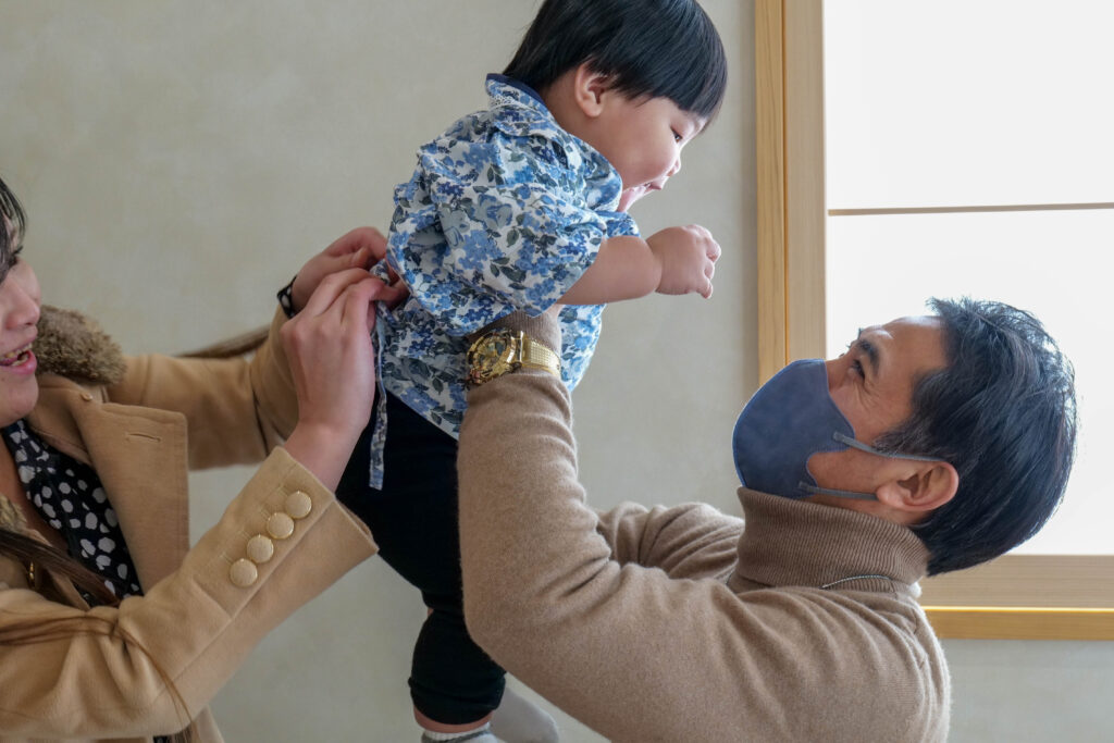 餅踏みのお着替えをする1歳の子ども