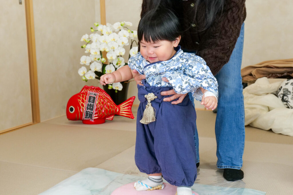 丸餅の上に立つ1歳の子ども