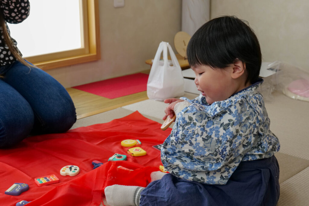 選び取りの道具を前に真剣に選ぶ1歳の子ども