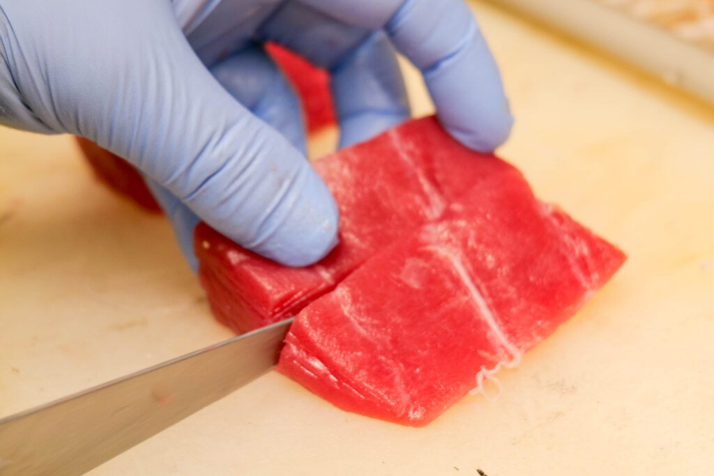 魚政で鮮魚を丁寧に切り分ける調理風景